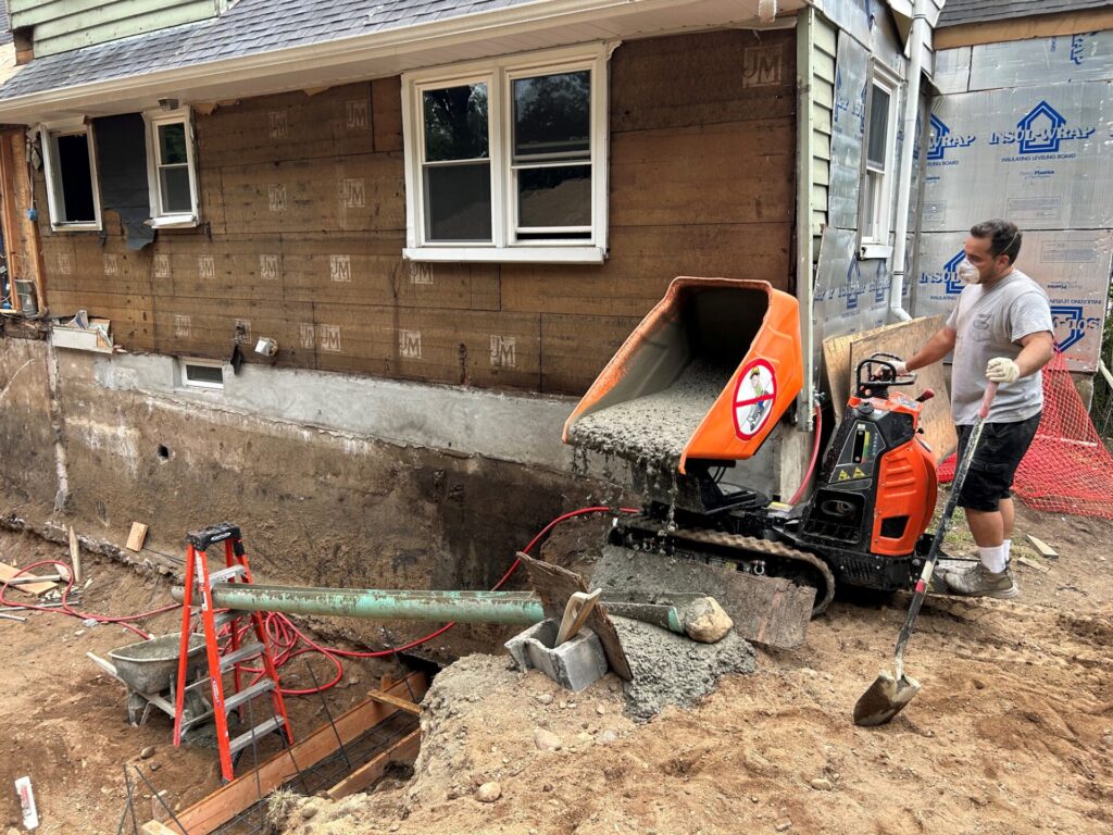 Man pouring cement with concrete buggy in New Jersey Man pouring cement with concrete buggy in New Jersey